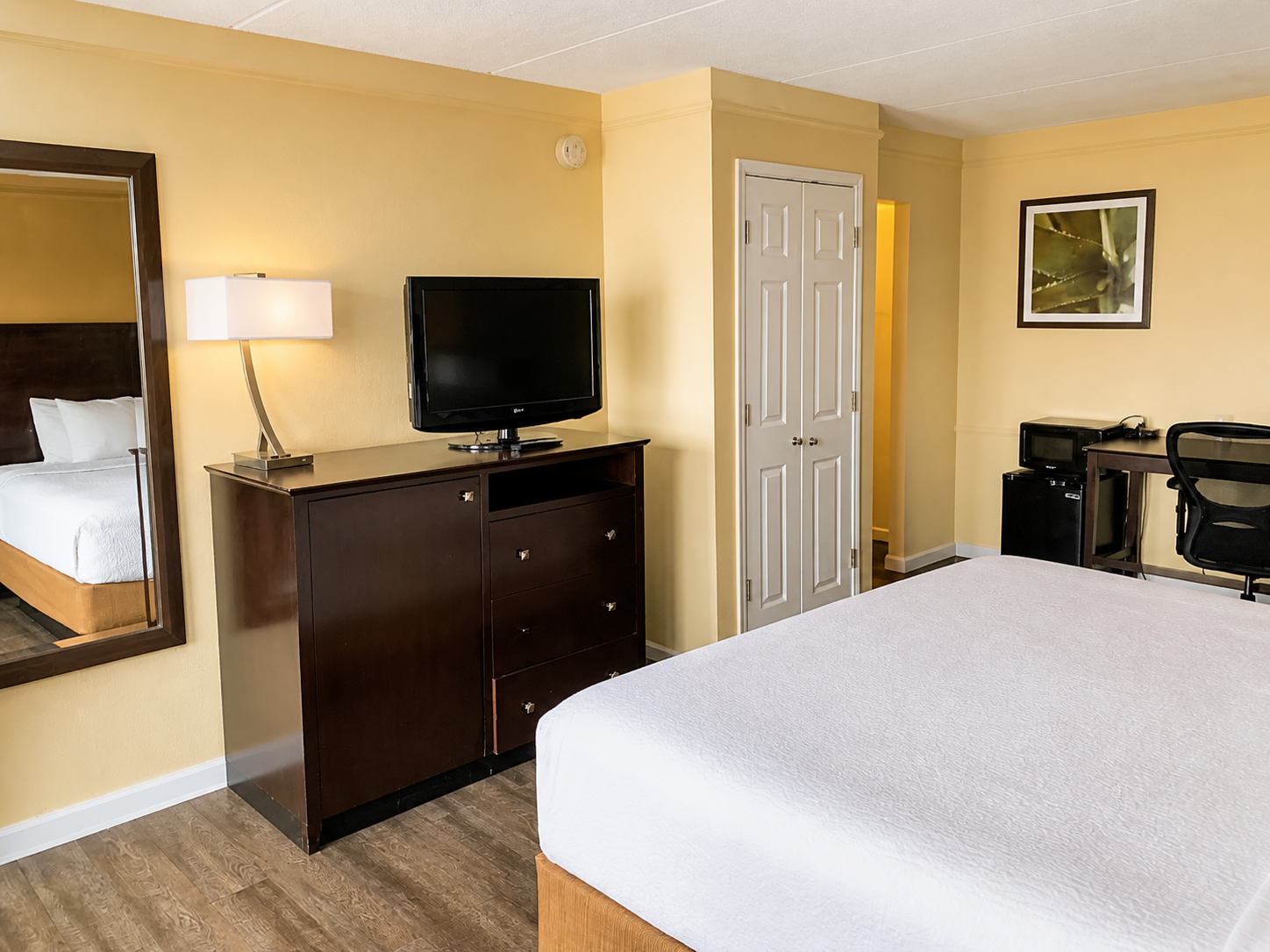 Montgomery king room with dresser, television, and work area