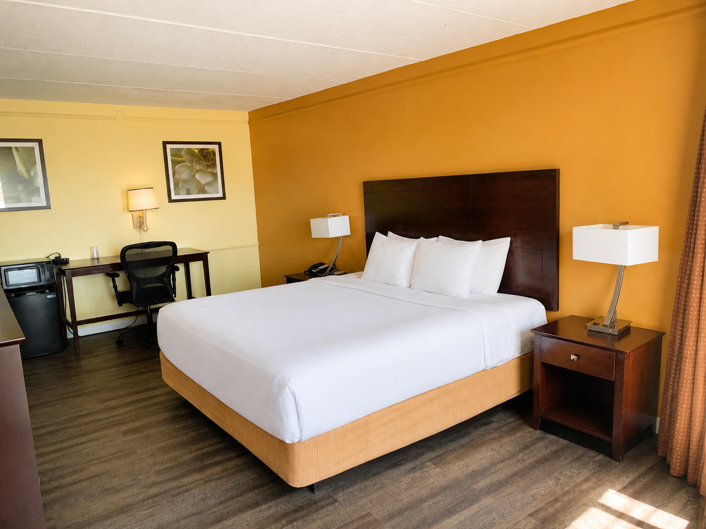 Montgomery king room with orange accent wall and workspace