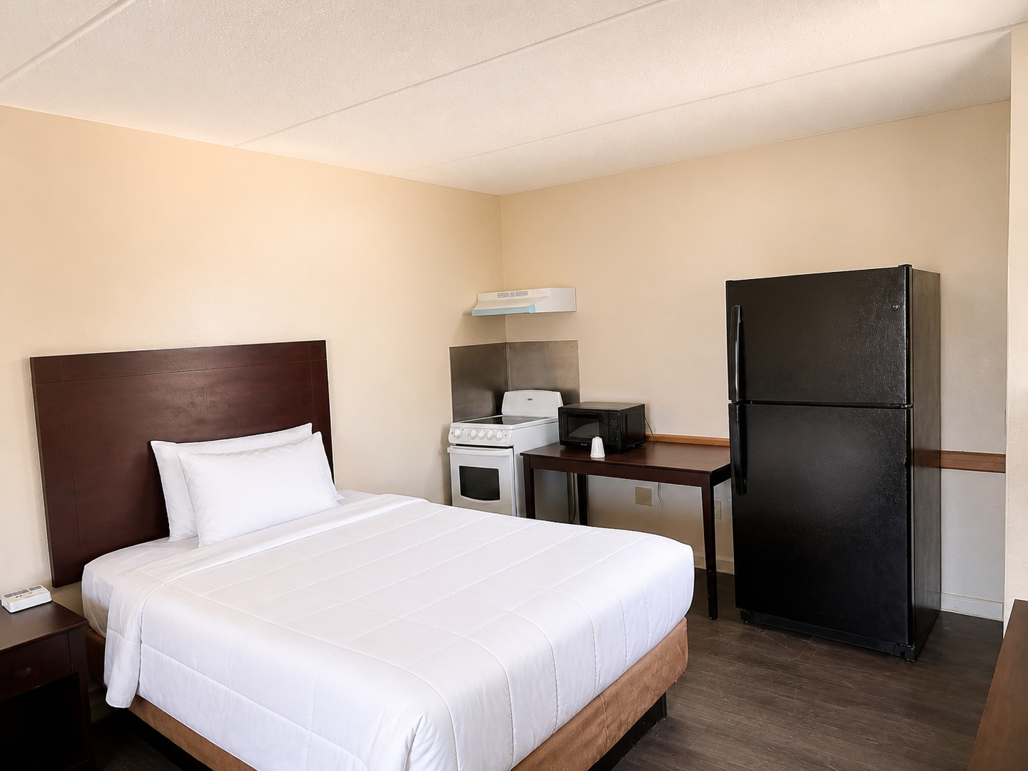 Montgomery room with queen bed, stove, microwave, and full-size refrigerator