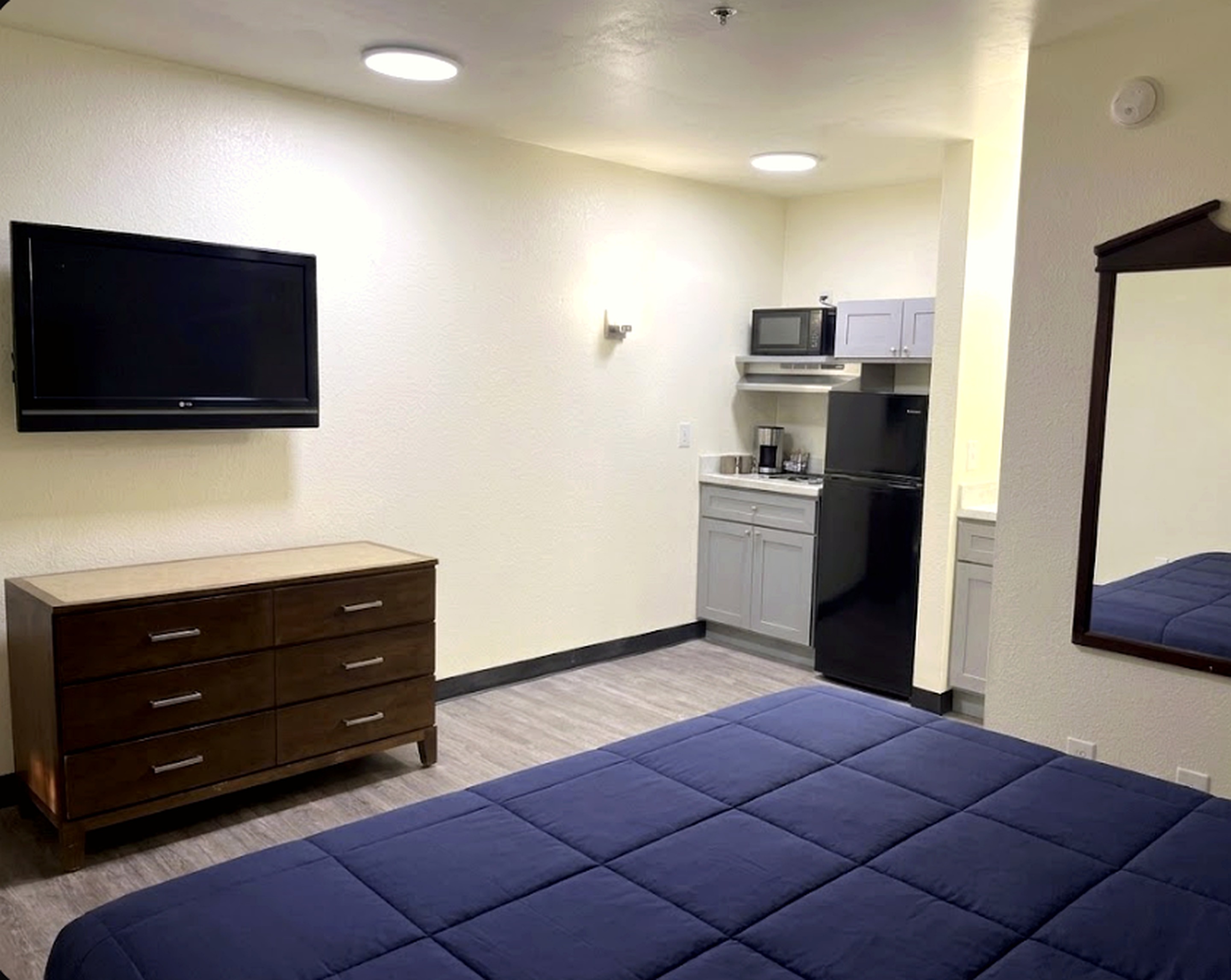 Savannah guest room with television, dresser, and kitchenette
