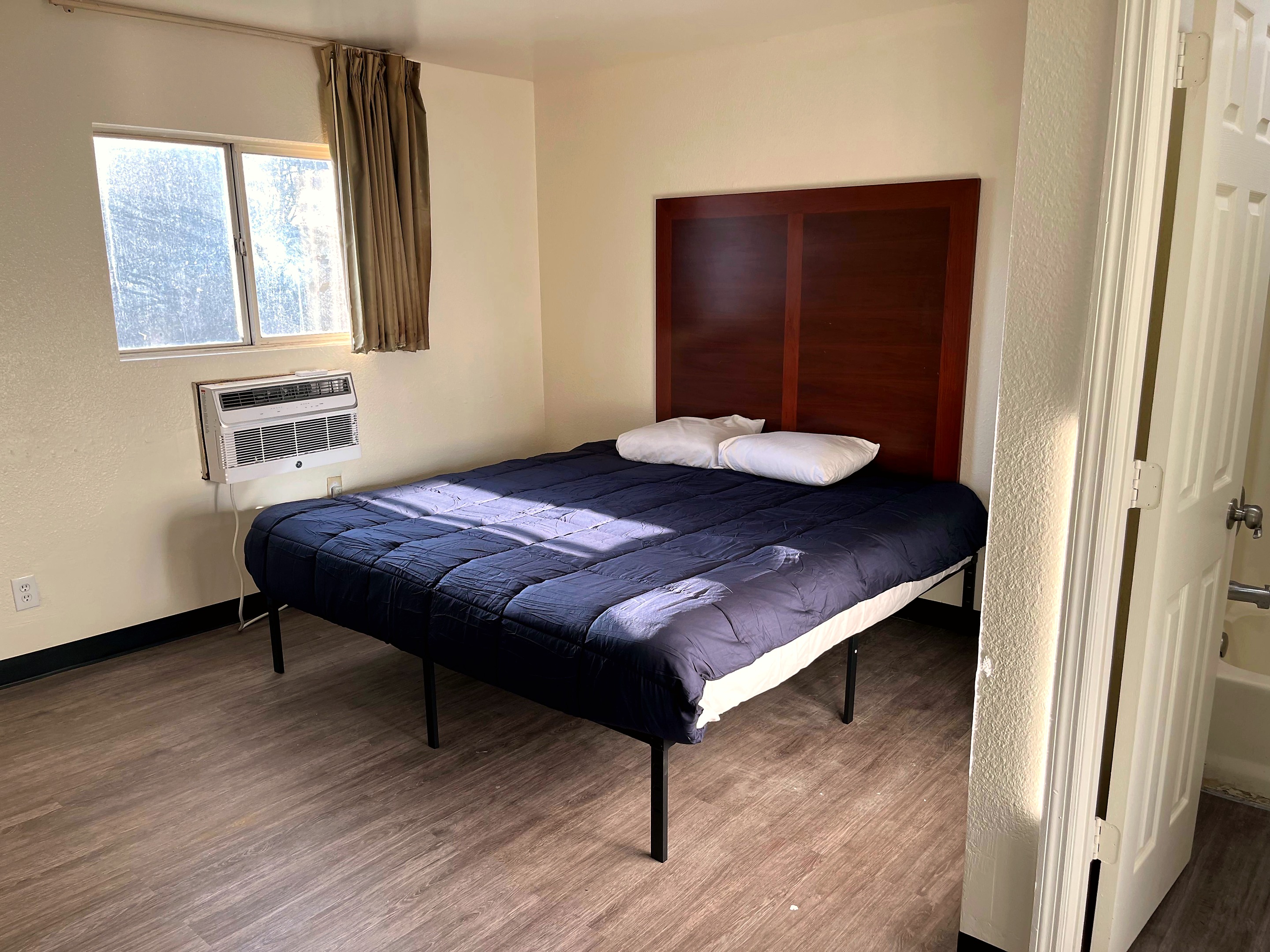 Savannah guest room with bed, dresser, TV, and kitchenette