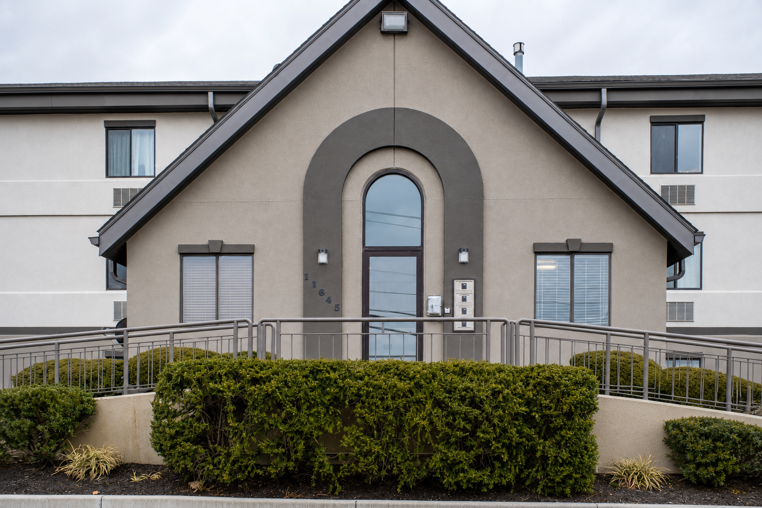 Springdale property entrance with glass door and shrubs