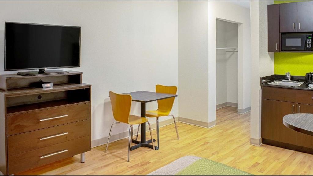 Springdale studio room with television, dining table, and kitchenette
